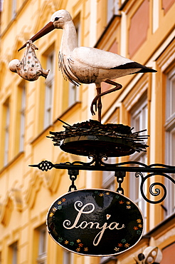 Sculpture of a stock holding a baby in front of a children's clothing shop, Bamberg, Upper Franconia, Bavaria, Germany