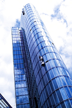 Window-cleaner cleaning the glass facade of a high-rise building, exterior