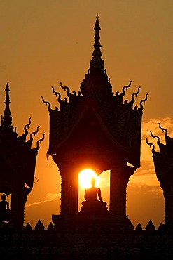 Sunset behind a Buddha statue at That Luang Vientiane, Laos, Asia