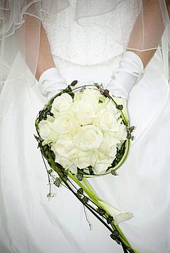 Bridal bouqet in front of the upper body of a bride