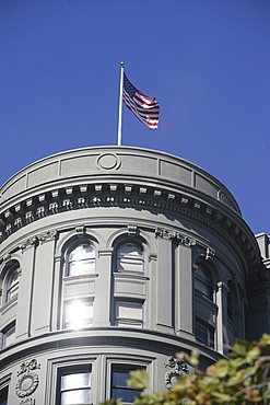 Stars and stripe sabove an high-rise building in n San Francisco California USA