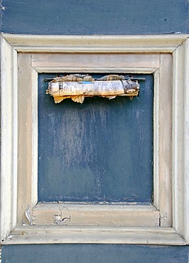 Old newspaper in a letter slot of a frontdoor