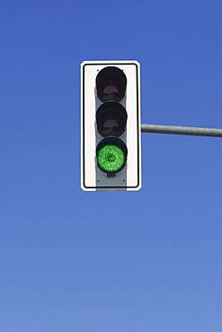 Green traffic light in blue sky