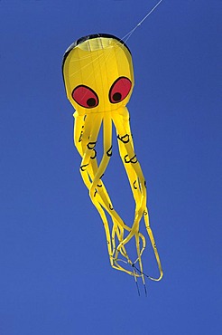 Yellow Kite in shape of an octopus with red eyes in the air