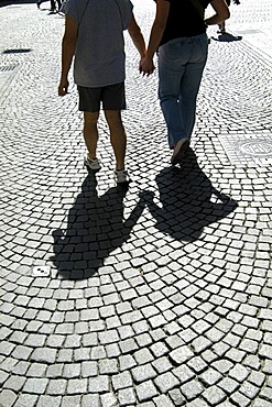 Young couple walking on pavement, sidewalk