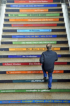 Man climbing steps covered with advertisements, Cologne, North Rhine-Westphalia, Germany, Europe