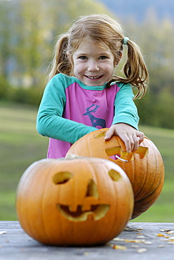 Girl carving a jack-o-lantern from a pumpkin for Halloween