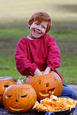 Boy carving a jack-o-lantern from a pumpkin for Halloween