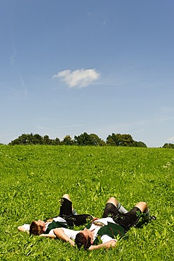 Two men in traditional Bavarian dress, Lederhose, on a meadow