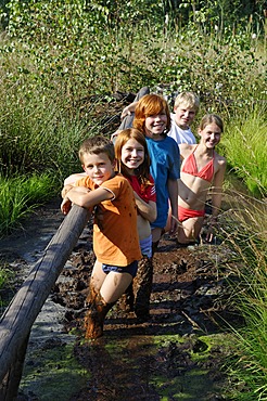 Children smeared with mud, mud bath in the Sterntaler Filze, moorland, peat fields in Bad Feilnbach, Upper Bavaria, Bavaria, Germany, Europe