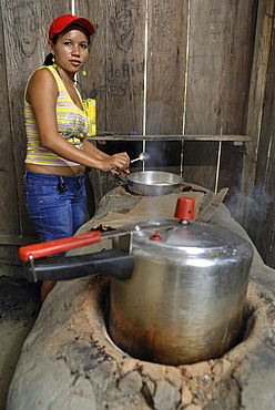 Woman cooking in simple kitchen, Amazon Basin, Brazil