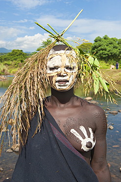 Young Surma woman with body painting in front of the river, Kibish, Omo valley Valley, Ethiopia, Africa