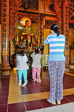 Women in prayer in a Buddhist temple, Vietnam, Asia