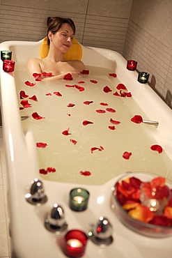 Woman, 35, relaxing in a bathtub with rose petals, Thalasso therapy in a spa resort