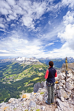 Climber crossing the Latemar massif, fixed rope route, Dolomites, on the Torre Diamantidi peak, in the back the Rosengarten group, South Tyrol, Italy, Europe