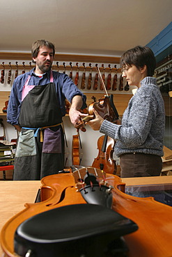 Violin-maker (luthier) with a customer in his shop