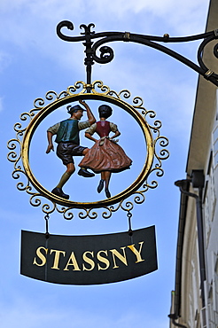 Hanging sign with figures in traditional costume of a children's costume shop, Salzburg, Salzburg province, Austria, Europe