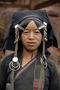 Portrait, ethnology, woman of the Akha Pixor ethnic group in traditional dress, hood as a headdress, wearing silver and coins as jewellery, village Ban Moxoxang, Phongsali district, Phongsali province, Phongsaly, Laos, Southeast Asia, Asia