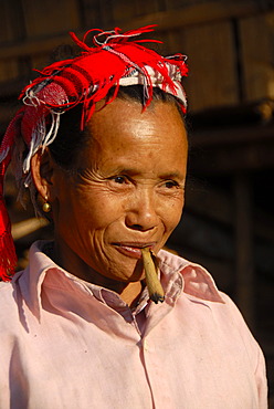 Portrait, woman of the Lao Seng ethnic group smoking a cigar, colorful headscarf, Ban Sopkang, Phou Den Din National Protected Area, Phongsali district and province, Laos, Southeast Asia, Asia