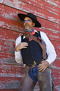 Cowboy leaning on barn wall, wildwest, Oregon, USA