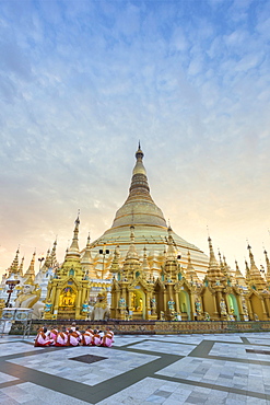 Nuns sitting in front of the Shwedagon pagoda, Shwedagon Paya, morning light, Yangon, Myanmar, Asia