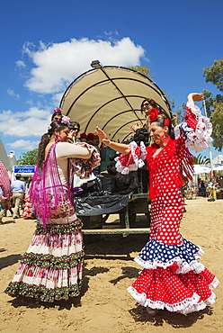 Women wearing colourful gypsy dresses dance the Sevillana, Pentecost pilgrimage of El Rocio, Huelva province, Andalusia, Spain, Europe