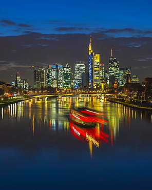 Trail of light from boat in front of skyline, blue hour, Osthafen, Frankfurt am Main, Hesse, Germany, Europe