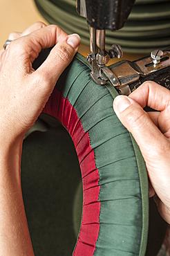 Hands sewing silk ribbon and inner lining on hat edge, hatmaker workshop, Bad Aussee, Styria, Austria, Europe