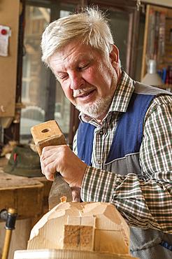 Wooden mask carver using wood carving tools on a wooden block, wooden mask, Bad Aussee, Styria, Austria, Europe