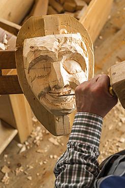 Carving the mouth of a wooden mask using wood carving tools, wooden mask carver, Bad Aussee, Styria, Austria, Europe