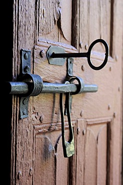 Old door of wood with its worn lock, Church in Cantal, Auvergne, France, Europe