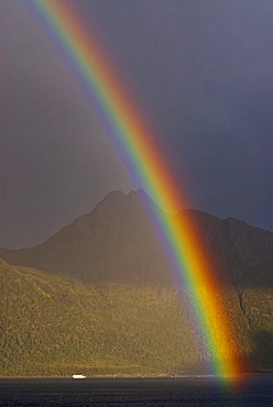 A rainbow over Melfjord with the misty mountains of the island of Senja at back, Troms, Norway, Europe