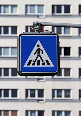 Pedestrian crossing sign in front of apartment buildings