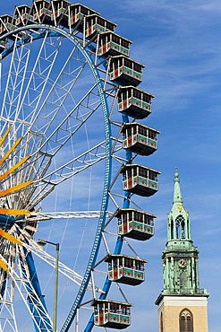 A ferris wheel and Marienkirche church on Alexanderplatz square, Berlin, Germany, Europe