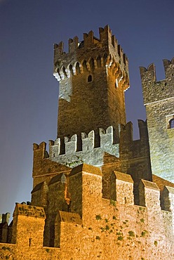 A flood-lit tower of the Scaliger Castle, Castello Scaligero, at the blue hour, in Sirmione, Lombardia, Italy, Europe