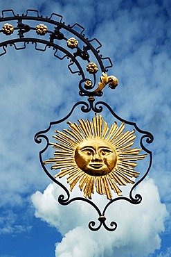 Hanging sign of "Hotel Gasthof Sonne", restaurant and hotel, against a cloudy sky, Hauptstrasse, Gengenbach, Baden-Wuerttemberg, Germany, Europe