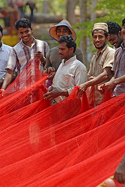 Fishermen holding a red fishing net, near Kasargod, Kerala, Malabar Coast, southern India, Asia