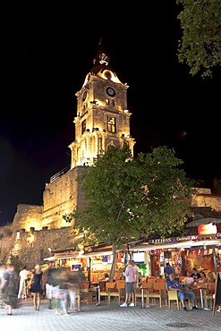 Clock tower, Odos Orfeas shopping street with sidewalk cafes at night, historic district of Rhodes, Rhodes, Greece, Europe, PublicGround