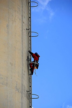 Chimney of Erlanger Stadtwerke heating plant, workman scaling chimney for repair works, Aussere Brucker Strasse 33, Elangen, Middle Franconia, Bavaria, Germany, Europe