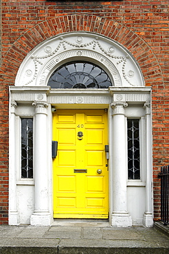 Yellow front door of a terraced house near Merrion Park, Dublin, Republic of Ireland, Europe