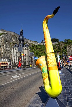 Pont du Charles de Gaulle bridge over the Meuse river with colorful saxophones as memorials to Adolphe Sax, Collegiate Church of Notre-Dame and Citadel, Dinant, Namur, Wallonia, Belgium, Europe