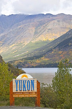 Yukon Territory welcome sign, South Klondike Highway, Indian summer, leaves in fall colours, autumn, Tagish Lake behind, Yukon Territory, Canada