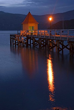 A pier and a lamp in twilight, in Akaroa, Banks Peninsula, Canterbury region, South Island, New Zealand