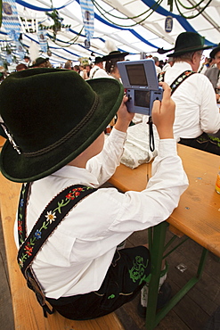 Young boy in Bavarian costume playing a computer game, Munich, Bavaria, Germany, Europe