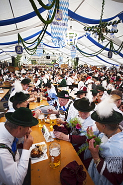 People in Bavarian costume inside beer tent, Oktoberfest, Munich, Bavaria, Germany