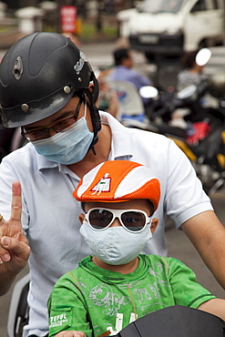 Motorbike passengers wearing pollution mask, Ho Chi Minh City, Vietnam, Indochina, Southeast Asia, Asia 