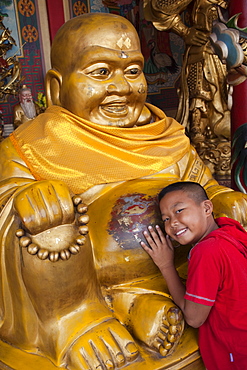 Young Boy with Buddha statue, Chinatown, Bangkok, Thailand, Southeast Asia, Asia