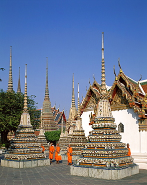 Monks walking past chedis, Wat Pho, Bangkok, Thailand, Southeast Asia, Asia