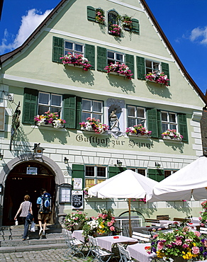 Couple entering typical guesthouse, The Old Town (Altstadt), Dinkelsbuhl, Bavaria, Romantic Road (Romantische Strasse), Germany, Europe