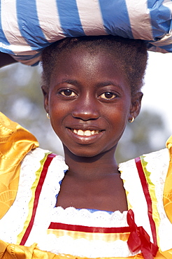 African girl carrying sack on head, Banjul, Gambia, West Africa, Africa